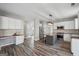 Open kitchen with stainless steel appliances, an island, access to other rooms, and wood-style flooring at 6448 Mobilis Ct, Sugar Hill, GA 30518