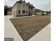 Beautiful two-story brick home with columns at the entrance and manicured lawn during winter at 829 Artistry Way, Fairburn, GA 30213