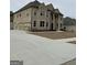 Two-story brick home with a prominent entrance featuring columns and arched windows, plus an attached two car garage at 829 Artistry Way, Fairburn, GA 30213