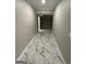 Hallway with marble tile flooring and recessed lighting, connecting various areas of the home at 829 Artistry Way, Fairburn, GA 30213