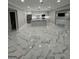 Bright open concept living area features marble tile floors, recessed lighting, and flows into a modern kitchen space at 829 Artistry Way, Fairburn, GA 30213
