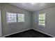 Bedroom with two windows showing the surrounding foliage and dark laminate floors at 4214 Canby Ln, Decatur, GA 30035