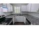 Well-appointed kitchen featuring white cabinets, granite countertops and tiled backsplash at 4214 Canby Ln, Decatur, GA 30035