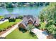 Stunning aerial view of brick home on waterfront with a lush lawn, mature trees, and expansive lake view at 1283 Heritage Dr, Villa Rica, GA 30180