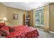 Bedroom features a red floral bedspread, a bookcase, and a bright window view at 1283 Heritage Dr, Villa Rica, GA 30180
