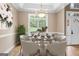 Staged dining room with round glass table and chairs, stylish decor, and hardwood floors, creating a warm ambiance at 1283 Heritage Dr, Villa Rica, GA 30180