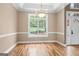 Elegant dining room featuring wood floors, a tray ceiling, and large window offering a bright and inviting space at 1283 Heritage Dr, Villa Rica, GA 30180