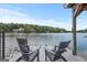 Relaxing lake view from the dock, featuring gray Adirondack chairs and serene water at 1283 Heritage Dr, Villa Rica, GA 30180