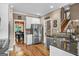 Open kitchen featuring granite countertops, stainless steel appliances, tile backsplash and hardwood floors at 1283 Heritage Dr, Villa Rica, GA 30180