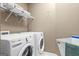 Efficient laundry room featuring a washer, dryer, and storage shelving for convenience at 1283 Heritage Dr, Villa Rica, GA 30180