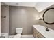 Cozy bathroom featuring a toilet, sink with a vanity, and a round mirror at 210 Steeple Point Dr, Roswell, GA 30076