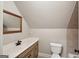 Bathroom featuring a vanity with a single sink, a framed mirror, and a toilet at 210 Steeple Point Dr, Roswell, GA 30076