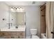 Neutral bathroom featuring a framed mirror, cabinets, and a tub with tiled walls at 210 Steeple Point Dr, Roswell, GA 30076