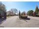 Elegant gated community entrance with landscaped roundabout and well-maintained brick pillars at 210 Steeple Point Dr, Roswell, GA 30076