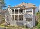 Rear exterior view of home featuring a covered back porch on two levels and an expansive backyard at 210 Steeple Point Dr, Roswell, GA 30076