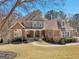 Charming two-story home with brick and stone accents, covered porch, and well-manicured front yard at 210 Steeple Point Dr, Roswell, GA 30076