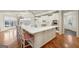 Open kitchen boasts all-white cabinets and countertops, stainless appliances, and a central island with barstool seating at 210 Steeple Point Dr, Roswell, GA 30076