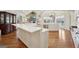 Open-concept kitchen offers stainless steel appliances, white cabinetry, and center island with a view of living room at 210 Steeple Point Dr, Roswell, GA 30076