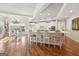 Spacious kitchen and dining area featuring white cabinets, hardwood floors, and bar seating at 210 Steeple Point Dr, Roswell, GA 30076