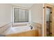 Bathroom features a jacuzzi tub with travertine surround and a glass enclosed shower at 210 Steeple Point Dr, Roswell, GA 30076