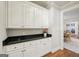 Butler's pantry features white cabinets, dark granite countertops, and wooden flooring at 210 Steeple Point Dr, Roswell, GA 30076
