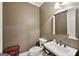 Cozy powder room with stylish dark beige walls, pedestal sink, and vintage mirror at 210 Steeple Point Dr, Roswell, GA 30076