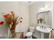 Charming powder room with pedestal sink, decorative mirror, and stylish floral arrangement at 210 Steeple Point Dr, Roswell, GA 30076