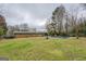 Expansive backyard view with a brick home, pool, and mature landscaping at 10174 Twin Oaks Sw Dr, Covington, GA 30014