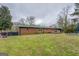 Expansive backyard featuring a brick home, a deck, and a pool area at 10174 Twin Oaks Sw Dr, Covington, GA 30014