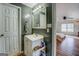 Bathroom with a white vanity, mirror with lighting, and wood-look flooring, offering a functional and clean space at 10174 Twin Oaks Sw Dr, Covington, GA 30014