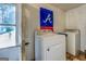 Functional laundry room with washer, dryer, and Braves decor at 10174 Twin Oaks Sw Dr, Covington, GA 30014
