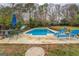 Inviting backyard pool area with lounge chairs, an umbrella, and green surroundings at 10174 Twin Oaks Sw Dr, Covington, GA 30014