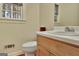 Well-lit bathroom with a classic vanity, toilet, and window providing natural light at 215 Farr Lake Dr, Tyrone, GA 30290