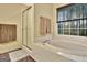 Bright bathroom showcasing a tub with a large window and a glass door shower at 215 Farr Lake Dr, Tyrone, GA 30290
