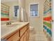 Bathroom showing a sink and vanity, toilet and a colorful striped shower curtain at 215 Farr Lake Dr, Tyrone, GA 30290
