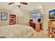 Attic bedroom with a ceiling fan, and a desk with shelving for work at 215 Farr Lake Dr, Tyrone, GA 30290