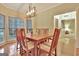 Well-lit dining room with hardwood floors, a wooden table, chairs, and a bay window at 215 Farr Lake Dr, Tyrone, GA 30290