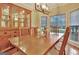 Well-lit dining room with a wooden table, matching chairs, china cabinet, and large bay window at 215 Farr Lake Dr, Tyrone, GA 30290