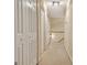 Well-lit hallway with carpet flooring, white doors, and a wooden railing at 215 Farr Lake Dr, Tyrone, GA 30290