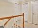 Hallway with stair railing and three doors with neutral paint at 215 Farr Lake Dr, Tyrone, GA 30290