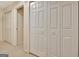 Bright hallway featuring multiple white closet doors and neutral carpet flooring at 215 Farr Lake Dr, Tyrone, GA 30290