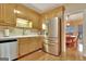 Well-lit kitchen with stainless steel appliances, white countertop, wood cabinets, and an adjacent dining area at 215 Farr Lake Dr, Tyrone, GA 30290
