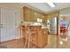 Kitchen area with breakfast bar, two stools, stainless steel refrigerator, and light wood cabinetry at 215 Farr Lake Dr, Tyrone, GA 30290
