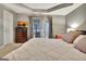 Cozy bedroom boasts balcony access, neutral tones, dresser and TV, perfect for relaxation at 215 Farr Lake Dr, Tyrone, GA 30290