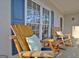 Relaxing front porch area with comfortable rocking chairs and blue accent shutters at 215 Farr Lake Dr, Tyrone, GA 30290