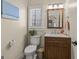 Cozy powder room with a framed mirror, wooden vanity, and natural light from the window with shutter at 125 Tall Timber Ct, Fayetteville, GA 30215