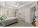 Bright bedroom featuring carpet, a ceiling fan, and doors to the walk-in closet and bathroom at 125 Tall Timber Ct, Fayetteville, GA 30215