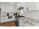 Modern kitchen design featuring stainless steel appliances, white cabinets, granite countertops and hardwood floors at 125 Tall Timber Ct, Fayetteville, GA 30215