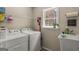 Functional laundry room with washer, dryer, utility sink, and a window for natural light at 125 Tall Timber Ct, Fayetteville, GA 30215