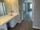 Bathroom with vanity and wood-look flooring leads into living area with multiple windows at 11 Carriage Lake Dr, Stockbridge, GA 30281